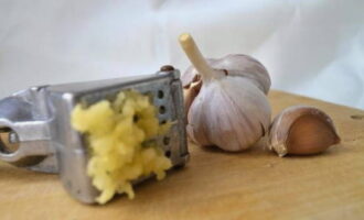 Tritureu els grans d'all pelats amb una premsa especial.