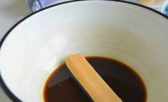 Häll kaffe i en separat djup skål. Häll kokande vatten över och brygg. Observera att kaffet måste vara naturligt. Kyl den färdiga drycken och häll sedan likör i den (du kan lägga till konjak eller någon annan alkoholhaltig dryck). Doppa kakorna snabbt i blandningen så att de inte hinner bli blöta. 