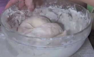 După o jumătate de oră, începem să frământăm aluatul. Adăugați puțin câte puțin făina rămasă și amestecați ingredientele în același timp. Când aluatul se îngroașă, turnați în el ulei vegetal.Continuam sa framantam. Când aluatul devine foarte gros, frământați-l cu mâinile. Lăsați așa timp de 30 de minute.