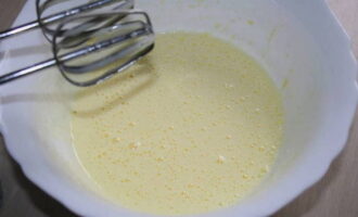 Hoe bak je weelderige pannenkoeken met appels op kefir in een koekenpan? Klop de eieren en suiker met een mixer tot een gladde massa. Giet kefir erbij, roer.