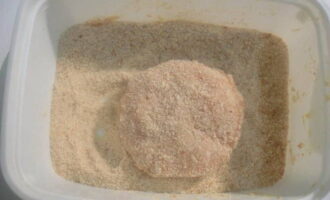 Blöt händerna i vatten och forma köttfärsen till runda bollar. Rulla dem sedan i ströbröd på alla sidor.