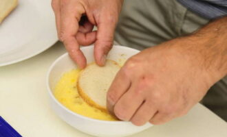 Aboqueu oli vegetal a la paella. Col·loqueu el recipient al foc encès i, mentre l'oli s'escalfa, enfileu les llesques de pa a una forquilla i les submergiu una a una en una barreja d'ous i llet.