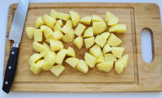 Rentar les patates amb aigua corrent i tallar-ne la pell amb un ganivet. Esbandiu les verdures d'arrel de nou i talleu-les a trossos grans. Poseu les patates a la paella amb les costelles i les verdures. Si no hi ha prou líquid al recipient, afegiu-hi una mica més d'aigua.