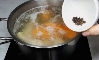 Voeg nu peperkorrels toe aan de kip en de groenten in de pan, dek de pan af met een deksel, zet het vuur laag en laat 1,5 uur koken. Het is belangrijk om de bouillon niet te veel te laten koken.