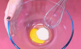 Hoe bak je broodjes met suiker in de oven? Klop in een kom een ​​ei, vanillesuiker, 30 gram totale suiker en zout.