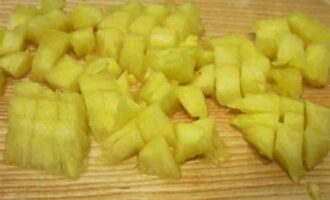Escorreu l'almívar d'una llauna de pinya en conserva i talleu la fruita a daus petits.
