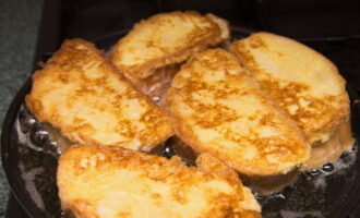 Poseu les llesques de pa a la paella. Fregiu-los per cada costat a foc fort fins que estiguin daurats. Es trigarà com a màxim un minut a fregir un costat. Aneu amb compte de no deixar que els crostons es cremin al fons de la paella.