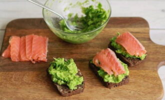Phết hỗn hợp xanh lên từng lát bánh mì và đặt các lát cá lên trên.
