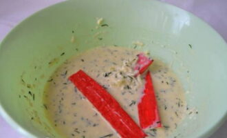 Remeneu fins que estigui suau. Col·loqueu bastonets de cranc a la massa preparada.