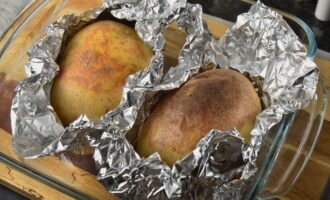 Open de oven en haal er een bakplaat met aardappelen uit. Open de folie en plaats de aardappelen terug in de oven gedurende 10 minuten. Verhoog de temperatuur naar 200 graden. 
