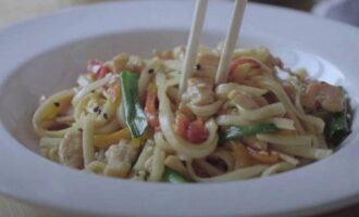 De smakelijke wok met kip en groenten is klaar. Help jezelf!