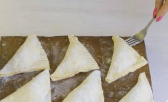 Aboqui una petita quantitat de farina en un plat petit. Agafeu una forquilla i col·loqueu les seves dents a la farina. Apliquem les dents enfarinades a les vores dels pastissos, formant així un bonic estampat.