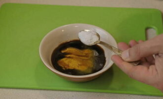 Hoe bak je heerlijk een varkensschenkel in een hoes in de oven? Meng honing met mosterd, sojasaus en zout.