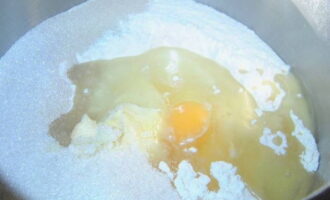 Giet tarwebloem door een zeef in een kom voor het kneden van deeg, voeg vier eetlepels suiker, een snufje zout, een lepel droge gist toe en meng goed. Giet vervolgens warme kefir in dit mengsel, breek een ei, voeg vijf eetlepels plantaardige olie en een lepel gesmolten boter toe en kneed het deeg met je handen tot het glad en elastisch is. 