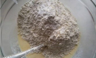 Într-un recipient separat, amestecați 2 căni de făină și o jumătate de linguriță de sifon. Cerne ingredientele vrac printr-o sită de mai multe ori. Apoi adăugați-le puțin câte puțin în amestecul lichid și începeți să frământați aluatul, care nu este prea gros.
