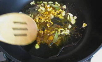 Se pun cateii de usturoi tocati in ulei incins, se prajesc putin, se adauga foi de dafin, coriandru, ienibahar, ghimbir si curry. Prăjiți condimentele câteva minute în timp ce amestecați.