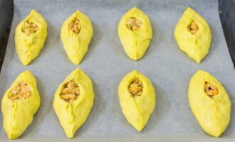 Cobriu una safata de forn amb pergamí. Disposeu els pastissos i deixeu els trossos durant 15-20 minuts perquè la massa pugi una mica més.