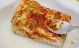 Barregeu adjika picant amb pasta de tomàquet en una tassa i apliqueu aquesta barreja a la superfície del carbonat al forn.