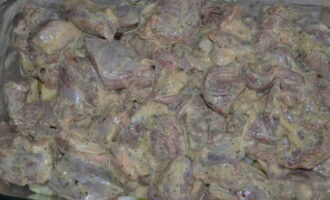 Puneți carnea de porc marinată deasupra stratului de legume. Maioneza se va topi în timpul coacerii, iar grăsimea ei se va înmuia în legume. Acoperiți tava cu un capac sau o bucată de folie și dați la cuptorul preîncălzit la 200 de grade pentru 1 oră.
