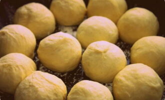 Als het deeg is gerezen, smeer je je handen in met plantaardige olie en vorm je het deeg tot balletjes van dezelfde grootte. Vet een bakplaat in met plantaardige olie, plaats de donuts op de bakplaat en laat ze 15-20 minuten rijzen. Bak de donuts vervolgens 10-15 minuten op 220 graden.