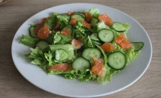 Snij de forelfilet in kleine stukjes en leg deze na de komkommer op het bord.