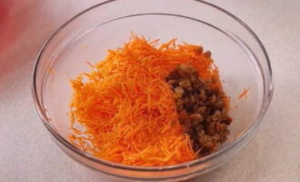 Giet gewassen rozijnen in de gehakte oranje groente.