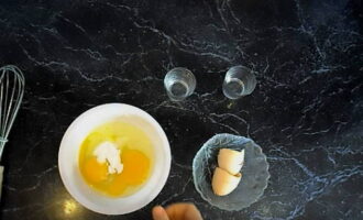 En un bol a part, barregeu dos ous de gallina amb sal i bicarbonat de sodi amb una forquilla.