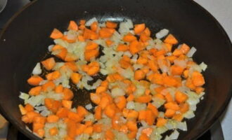 Zet de braadpan op het vuur, giet de plantaardige olie erin. Voeg als de olie heet is de ui toe en bak deze 5-7 minuten. Voeg vervolgens de wortels toe en kook nog 3-4 minuten.