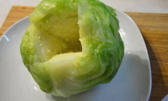 Ta försiktigt bort kålhuvudet från det kokande vattnet, låt det svalna lite och låt överflödig fukt rinna av, skär sedan ut stjälken.