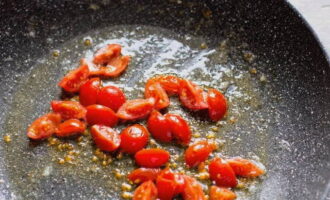 Poseu la paella a foc moderat i foneu la mantega, després afegiu-hi els tomàquets picats i deixeu-ho coure a foc lent durant uns minuts.