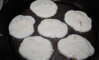 Giet plantaardige olie in de koekenpan en verwarm deze. Leg een eetlepel deeg en bak de pannenkoeken aan beide kanten goudbruin.
