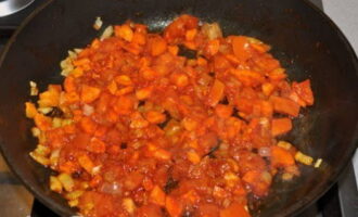 Snijd daarna de tomaat in blokjes en doe deze in een koekenpan, bak de groenten 2-3 minuten onder voortdurend roeren. Voeg vervolgens de tomatenpuree toe, wacht tot het braden kookt en voeg de stoofpot toe. Kook op middelhoog vuur gedurende 3 minuten en voeg dan suiker toe.