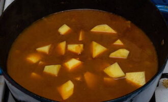Tăiați cartofii cubulețe, adăugați-i în carne și adăugați apă, astfel încât să acopere conținutul cratiței. Tăiați cartofii cubulețe, adăugați-i în carne și adăugați apă, astfel încât să acopere conținutul cratiței.