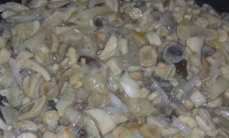 Voeg de champignons toe aan de gebakken uien en bak ze zonder de pan af te dekken met een deksel totdat het champignonsap volledig is verdampt. Tegen het einde van het frituren, zout de vulling naar uw smaak.