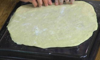 Gireu la safata de forn cap al revers, unteu-la amb oli i col·loqueu-hi amb cura la capa de massa estirada. Gireu la safata de forn cap al revers, unteu-la amb oli i col·loqueu-hi amb cura la capa de massa estirada.