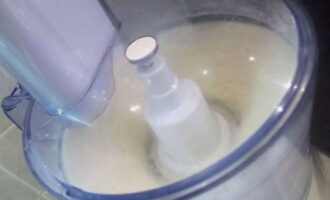 Dek de kom af met een deksel, plaats deze op een keukenmachine en kneed het deeg op gemiddelde snelheid gedurende 1-2 minuten.
