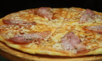 Se răcește puțin pizza, se taie în porții și se servește.