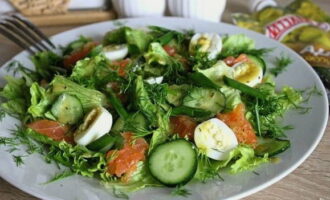 Giet de bereide dressing over de salade en strooi er gehakte dille en groene uien overheen. Serveer direct na bereiding.