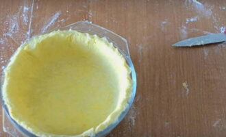 Cán bột đã nguội thành một chiếc bánh phẳng mỏng và đặt vào khay nướng, tạo thành các cạnh dọc theo mép.