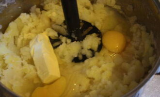 Kook op dit moment de geschilde aardappelen in gezout water en pureer ze met de toevoeging van eieren en boter tot een puree. 