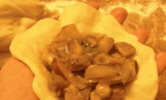 Kneed het deeg vervolgens opnieuw, verdeel het in kleine stukjes en rol ze uit tot dunne platte koeken. Leg op elk platbrood een lepel champignonvulling en druk de randen goed dicht. Om te voorkomen dat het deeg aan je handpalmen en de tafel blijft plakken, smeer je ze in met plantaardige olie.