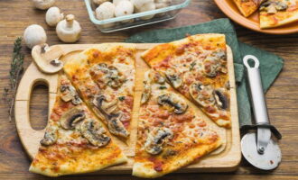Espolvorear la pizza de bolets acabada amb oli d'oliva, dividir en porcions i servir.