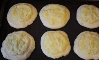 We brengen de bereidingen over naar een bakplaat, vooraf bedekt met plantaardige olie. We maken een kleine inzinking in het midden van elk plat brood en leggen de vulling neer, waarbij we deze bijna over het hele oppervlak van de bovenkant verdelen. Bestrijk met losgeklopt ei en zure room en plaats in de oven gedurende 15-20 minuten op 180 graden.