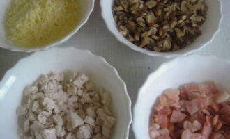 Julienne în tartele cu pui și ciuperci la cuptor este foarte ușor de preparat. Pregătim ingredientele pentru umplutură: râdem brânza, prăjim ușor pieptul, tăiem fileul în cuburi sau îl despărțim în fibre și scurgem excesul de lichid din ciuperci. 