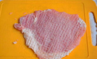 Het bereiden van varkenskarbonades in de oven is heel eenvoudig. Snijd het varkensvlees in dunne laagjes en klop ze met een keukenhamer.