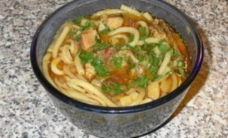 Voeg noedels toe aan de lagman en bestrooi het gerecht met gehakte kruiden, roer en serveer.