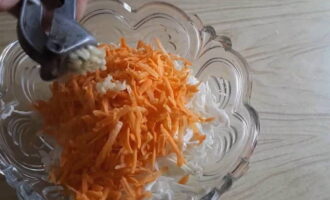 De wortels worden geschild, gewassen en op een grove rasp gehakt. Vervolgens wordt het overgebracht naar de kool. Voeg twee teentjes gehakte knoflook toe aan de salade.