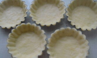 Împărțiți aluatul răcit în părți egale, rulați-l în prăjituri plate și tapetați cu ele formele de brioșe. Se usucă la cuptor pentru aproximativ 5 minute la 180 de grade.