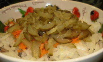 Tăiem castraveții murați sau murați după dorință și îi combinăm cu alte ingrediente ale preparatului.