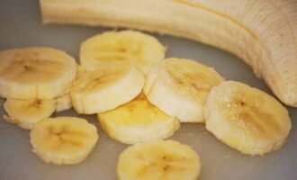 Ang mga saging ay dapat munang banlawan ng tubig na tumatakbo at punasan ng tuyo ng isang tuwalya, pagkatapos ay maingat na balatan at gupitin sa manipis na hiwa.